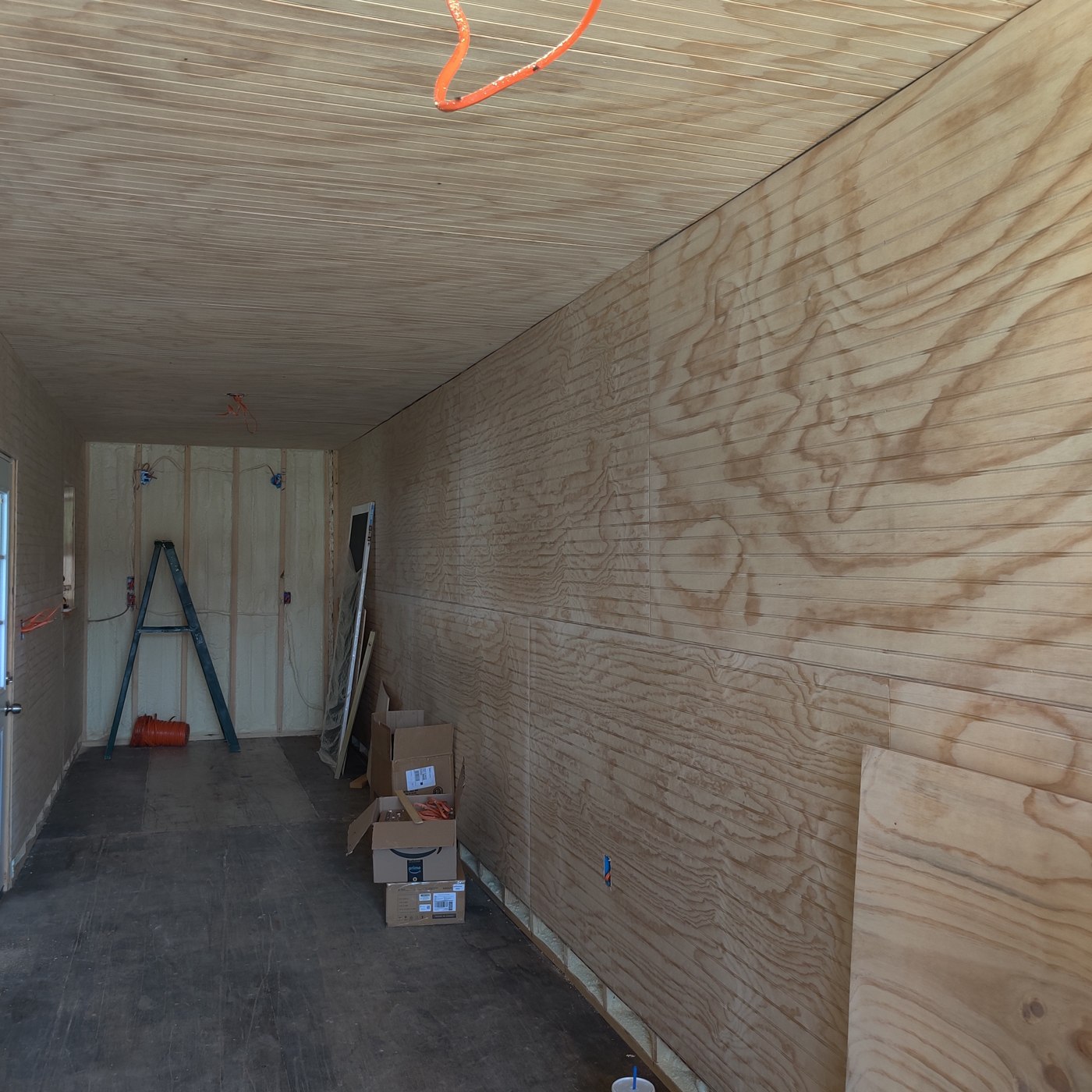 Container renovation with wood-lined interior and shelving